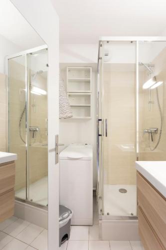une salle de bain avec une douche en verre et des toilettes dans l'établissement Chez Hervé - Charmant appartement avec piscine et parking, à La Grande Motte