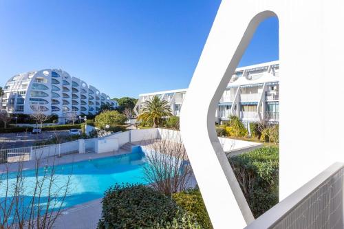 - une vue sur la piscine et les bâtiments de l'hôtel dans l'établissement Chez Hervé - Charmant appartement avec piscine et parking, à La Grande Motte