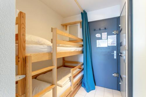 Cette chambre dispose de lits superposés avec 2 lits superposés et une porte. dans l'établissement Chez Hervé - Charmant appartement avec piscine et parking, à La Grande Motte