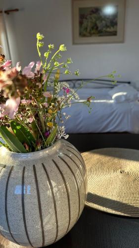 a vase with flowers on a table in a bedroom at Papanestoras Apartments in Kardamili