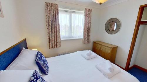 a small bedroom with two beds and a window at F74 Chyandour, Riviere Towans in Hayle