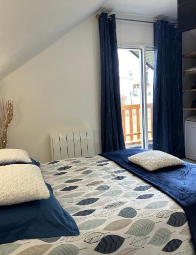 a bedroom with a bed with blue curtains and a window at Chambre dans résidence à proximité de sentiers de randonnée incroyables in Remiremont