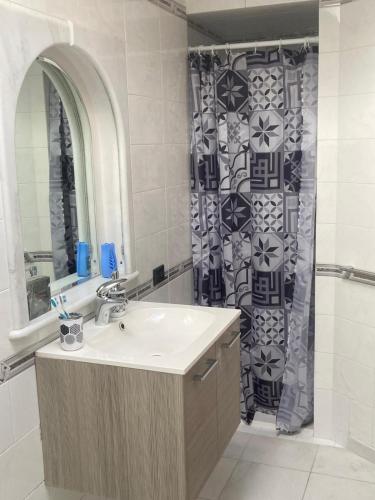 a bathroom with a sink and a shower curtain at Zanella House in Quartu SantʼElena