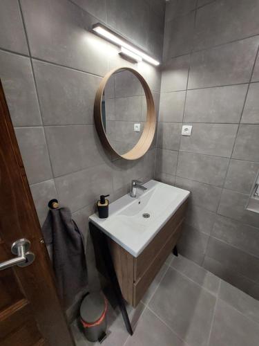 a bathroom with a sink and a mirror at Gilbert Apartman in Doboz