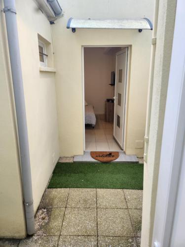 a hallway of a house with a door and grass at Maison studio in Paris