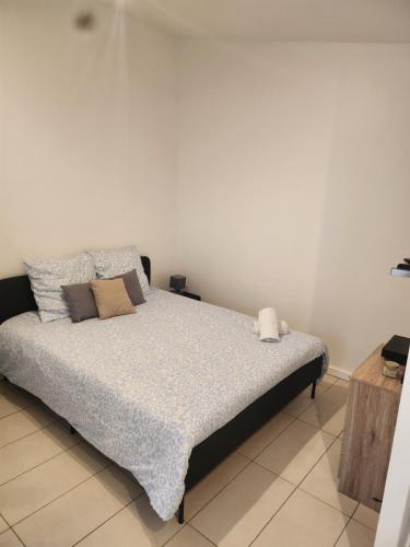 a bed in a room with a white wall at Maison studio in Paris