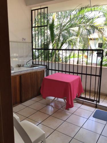 a kitchen with a table with a pink table cloth on it at Hotel Villa Tulipanes in Zihuatanejo