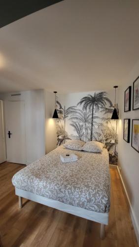 - une chambre avec un lit orné d'une fresque murale représentant des palmiers dans l'établissement Studio Ceineray 2pers, à Nantes
