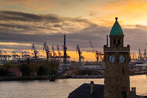 a clock tower with a green roof on top of a building at Urban Heaven Aparthotel in Hamburg