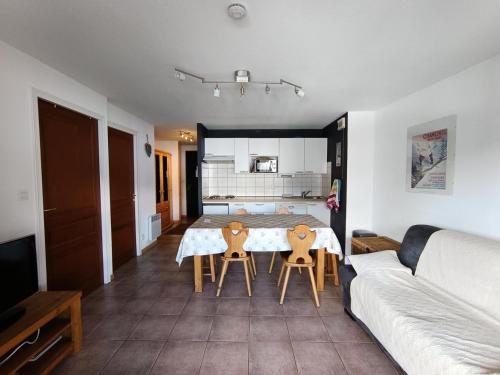 un salon avec une table, des chaises et un canapé dans l'établissement Résidence Plein Soleil - Appartement plein sud avec superbe vue, balcon, parking. MAE-9004, à Montgenèvre