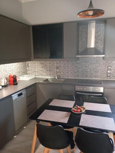 a kitchen with a table and chairs and a sink at Zoe's Apartment in Pídima Kyrás