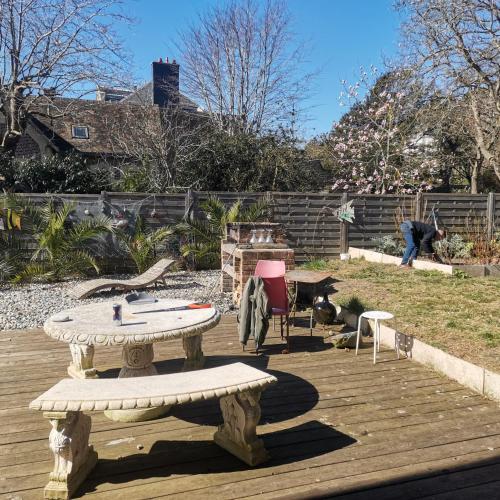 une table et un banc sur une terrasse en bois dans l'établissement cétamé, à Étretat
