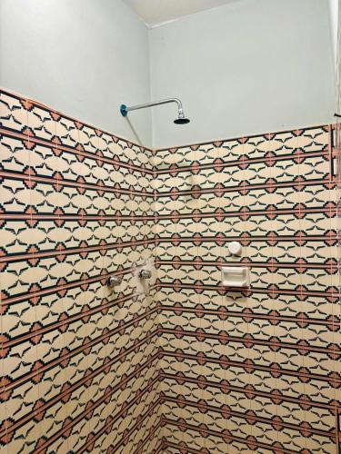 a bathroom with a tiled wall with a toilet at Casa María Bonita in Boca del Río