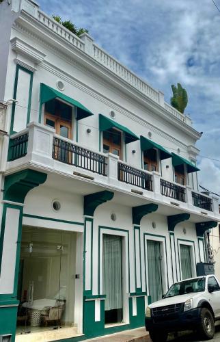 a building with a car parked in front of it at Boutique Hotel Casa Grande, Banana Chica, Estudio superior con cocina in Santo Domingo