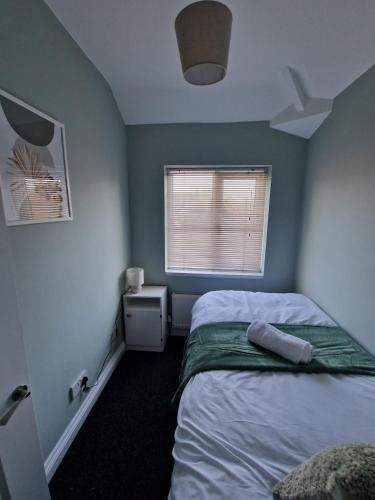 a small bedroom with a bed and a window at Cosy 3 Bed House Excellent Location NEC BHX HS2 Hot Tub Lazy Spa in Birmingham