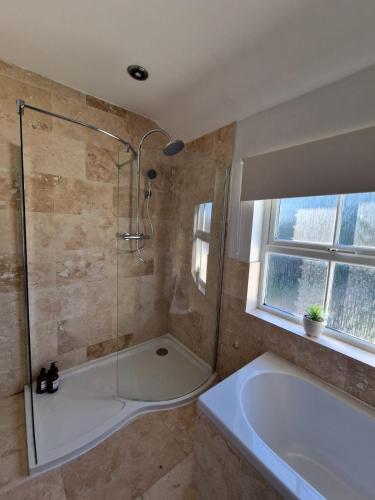 a bathroom with a shower and a bath tub at Cosy 3 Bed House Excellent Location NEC BHX HS2 Hot Tub Lazy Spa in Birmingham