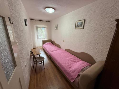 a bedroom with a bed with a pink blanket at Holiday Home Stone House in Perast