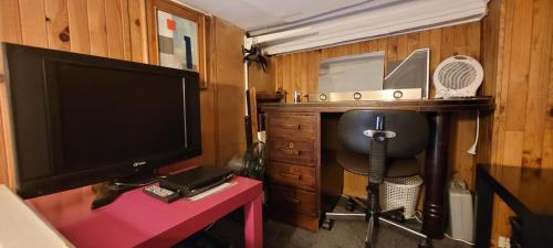 un salon avec une télévision et un bureau avec une chaise dans l'établissement Le 35 rue Coquillière with airport pick-up service, à Paris