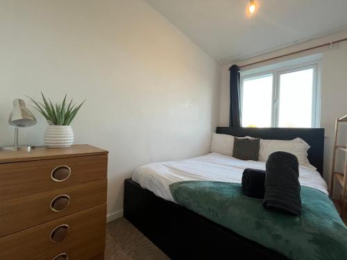 a bedroom with a bed and a dresser and a window at Cosy 2 Bedroom Apartment near City Centre in Manchester