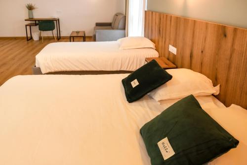a hotel room with two beds with white sheets at Auberge les Oliviers in Lucciana
