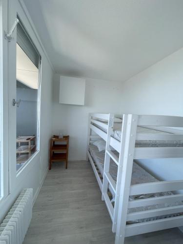 Cette chambre dispose de lits superposés, d'un bureau et d'une fenêtre. dans l'établissement Les Carlines 1793 T2 4-6 pers avec vue panoramique, à Chamrousse