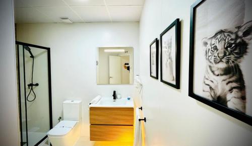 a bathroom with a sink and a tiger picture on the wall at Apartamentos Guerrero in Merida