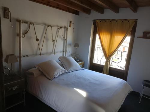 a bedroom with a large white bed and a window at La Casa de Forja in Tarilonte
