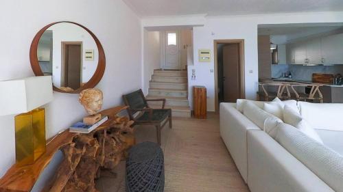 a living room with a white couch and a mirror at Villa Horizontes 1 in Possidi