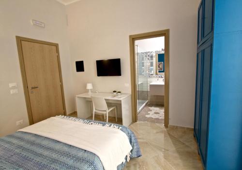 a bedroom with a bed and a desk and a television at La Passeggiata di Girgenti in Agrigento