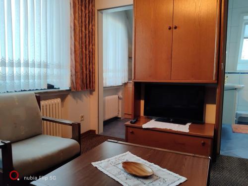 a living room with a table and a tv at Haus Ausreißer 2 - Heimathafen in Bensersiel
