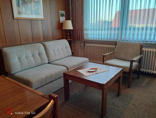 a living room with a couch and a table at Haus Ausreißer 2 - Heimathafen in Bensersiel