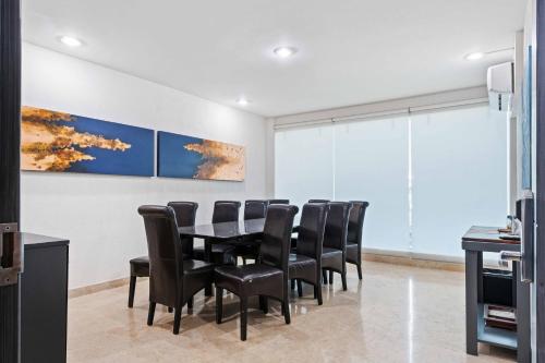a conference room with a table and black chairs at Homesuites Rotarismo in Culiacán