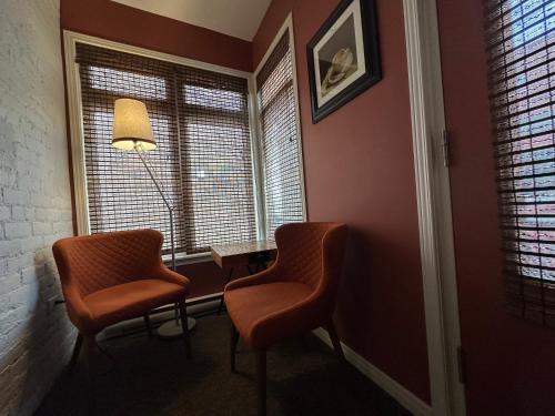 two chairs in a room with two windows at Auberge aux Deux Lions in Quebec City
