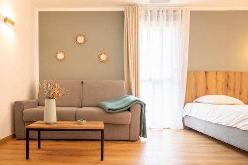 a living room with a couch and a bed at Auberge les Oliviers in Lucciana