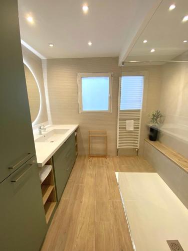 a large bathroom with a sink and a tub at La Loupiote - Jacuzzi compris SANS supplément ! in Lupcourt