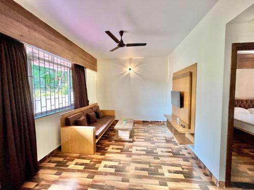 a living room with a couch and a tv at Lykke Suites- 2-min Drive to Colva Beach-By Goan Felicidade Hospitality PVT LTD in Colva