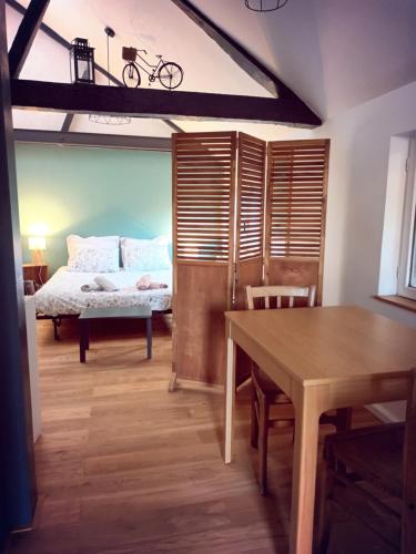 - une chambre avec un lit et une table avec un vélo sur le mur dans l'établissement Le 110 Bis, à Amboise