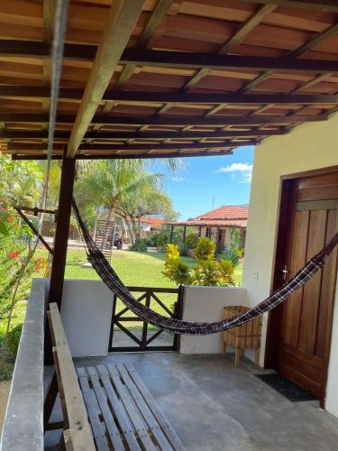 a hammock on the porch of a house at POUSADA DO BETO in Atins