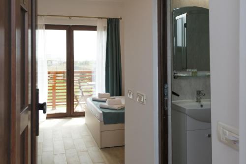 a bathroom with a sink and a mirror at Pensiunea EVIA CORBU in Corbu