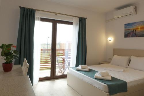a bedroom with a bed and a sliding glass door at Pensiunea EVIA CORBU in Corbu