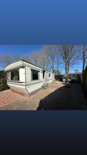 a tiny house sitting on top of a yard at Stacaravan 130 De Tien Heugten in Schoonloo