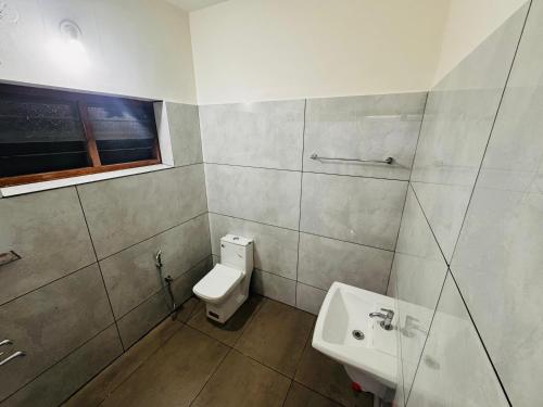 a bathroom with a toilet and a sink at BougainVilla in Trivandrum