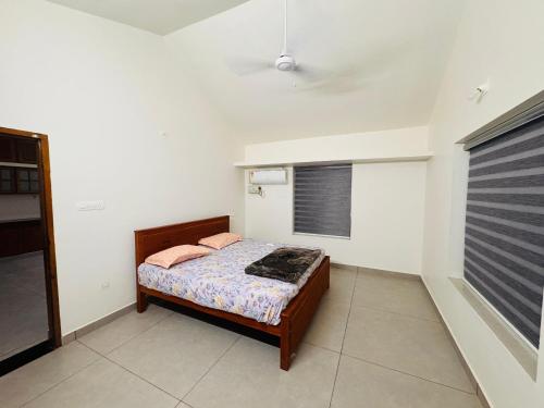 a bedroom with a bed and a window at BougainVilla in Trivandrum