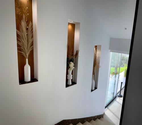 a white wall with three vases and flowers on it at Tanger Miramonte - Resort Suites & Double Rooms in Tangier