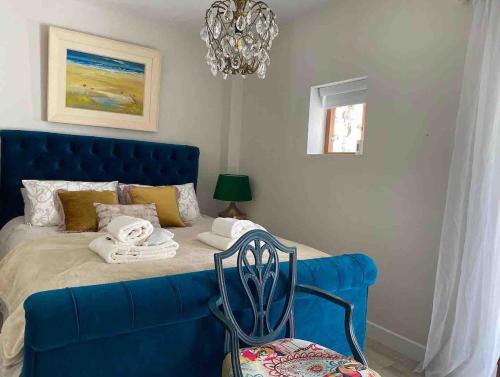 a blue bed with a blue couch in a room at Beautiful renovated stone house for Dog friendly, Quayside location in Newport