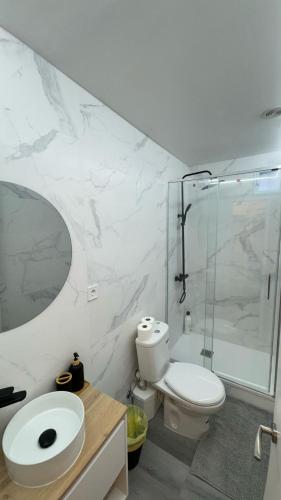 a bathroom with a toilet and a glass shower at JACUZZI ROOMS Atocha in Madrid