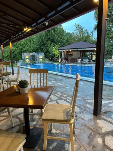 a patio with a table and chairs and a pool at Archontiko Liamas in Stavros