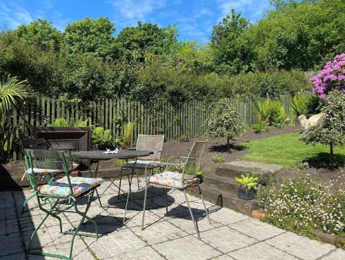 a patio with a table and chairs in a garden at Beautiful renovated stone house for Dog friendly, Quayside location in Newport