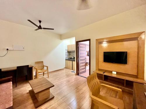 a living room with a television and a dining room at Lykke Suites- 2-min Drive to Colva Beach-By Goan Felicidade Hospitality PVT LTD in Colva