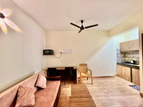 a living room with a couch and a ceiling fan at Lykke Suites- 2-min Drive to Colva Beach-By Goan Felicidade Hospitality PVT LTD in Colva